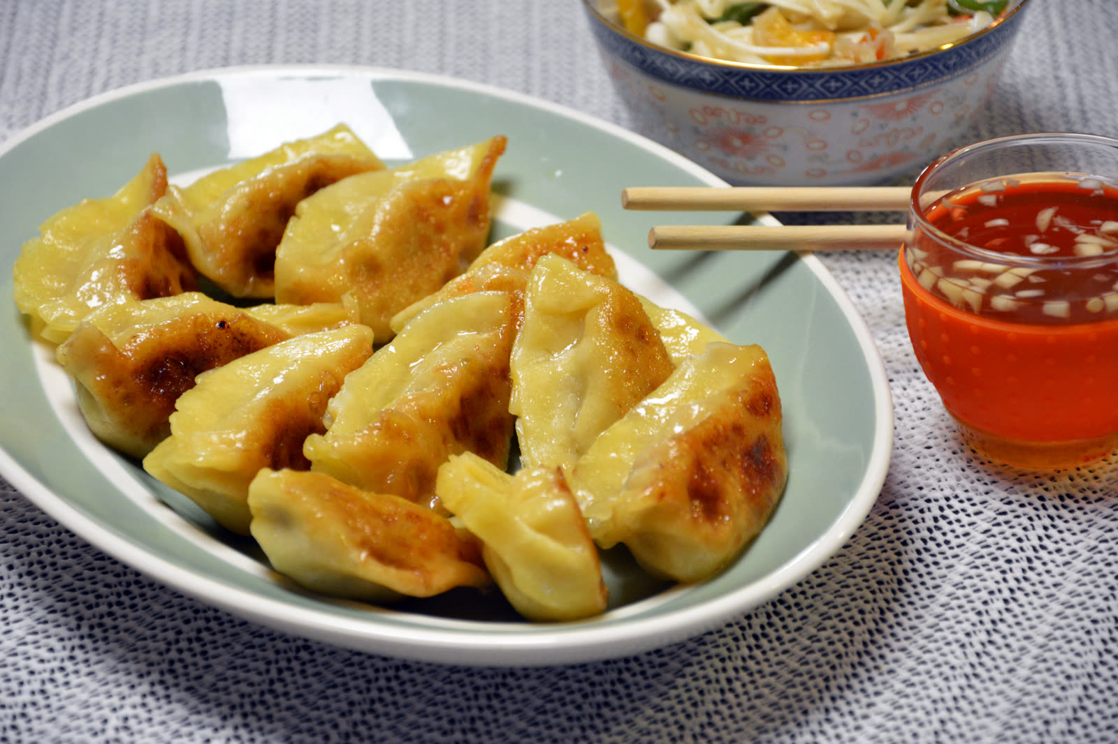 Hjemmelagde dumplings med sprø bunn stekt i panne, servert med dipp