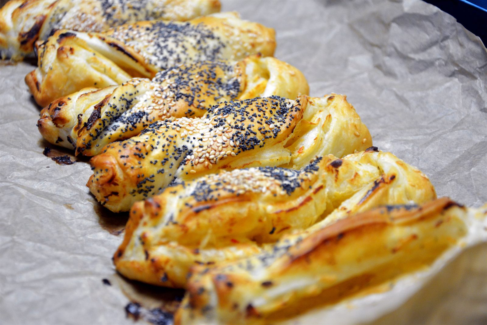 Nystekte frøsnappere av butterdeig med blå valmuefrø og sesamfrø på bakepapir