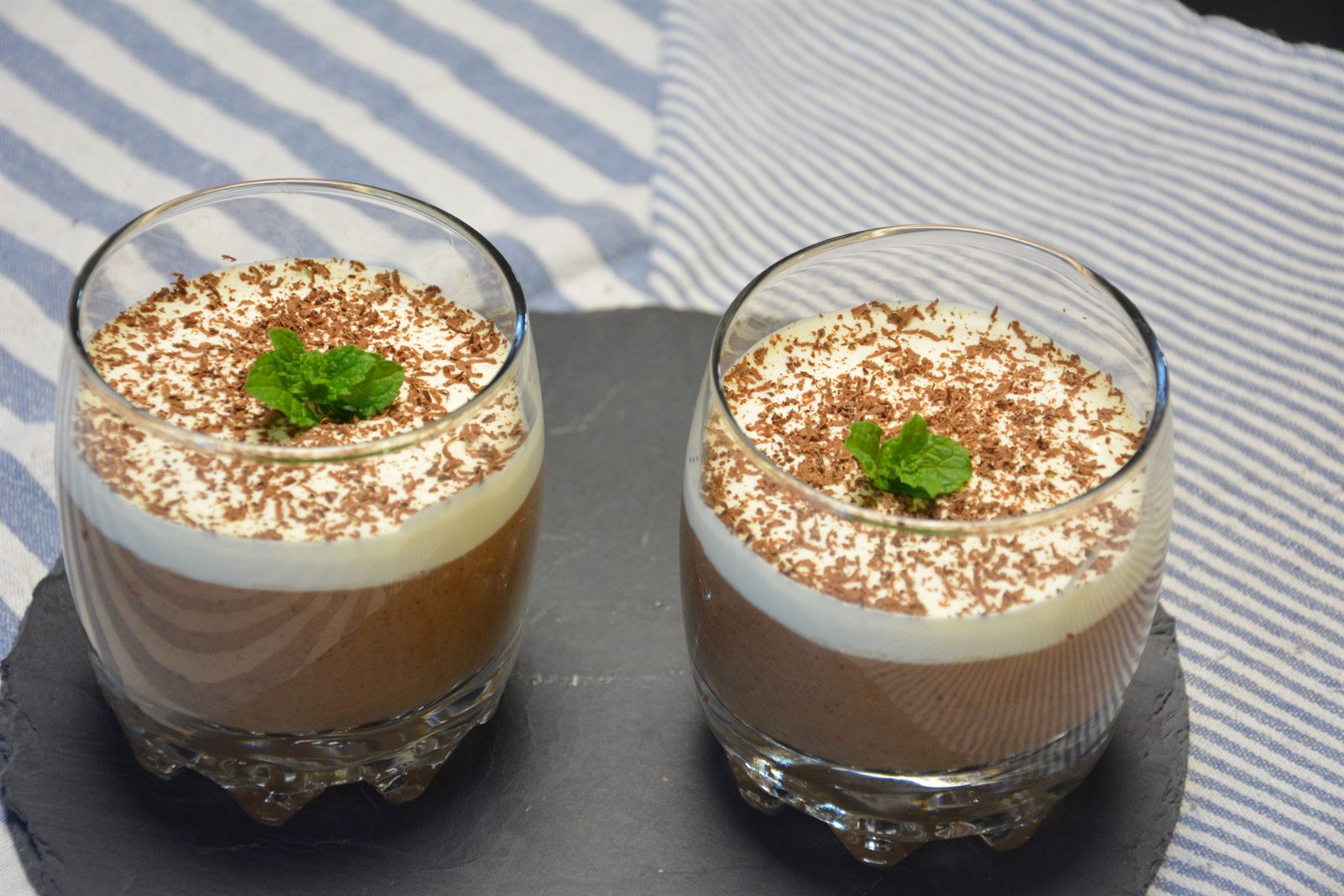 To glass med hjemmelaget sjokolademousse toppet med krem, revet sjokolade og friske mynteblader