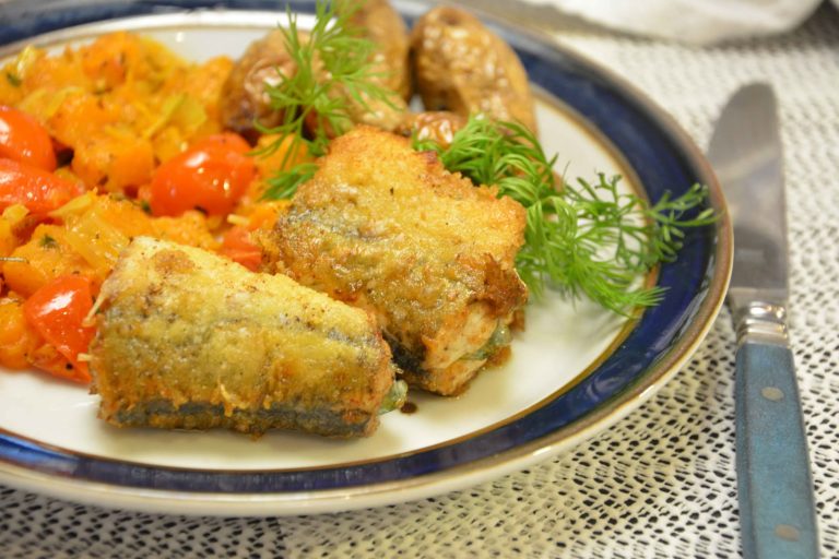 Stekt horngjel i gylne biter på en tallerken med blå kant, servert med gresskar, cherrytomater, dill og pannestekte poteter