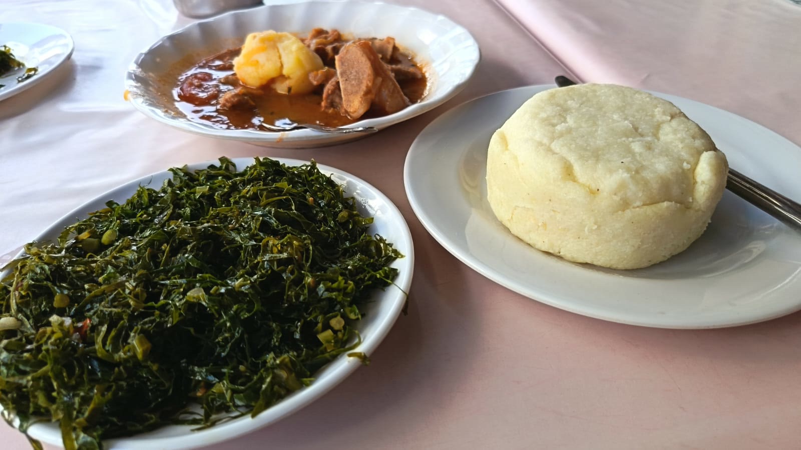 Hvit kuppel av ugali servert med sukuma wiki og kjøttgryte på godtnoe.no
