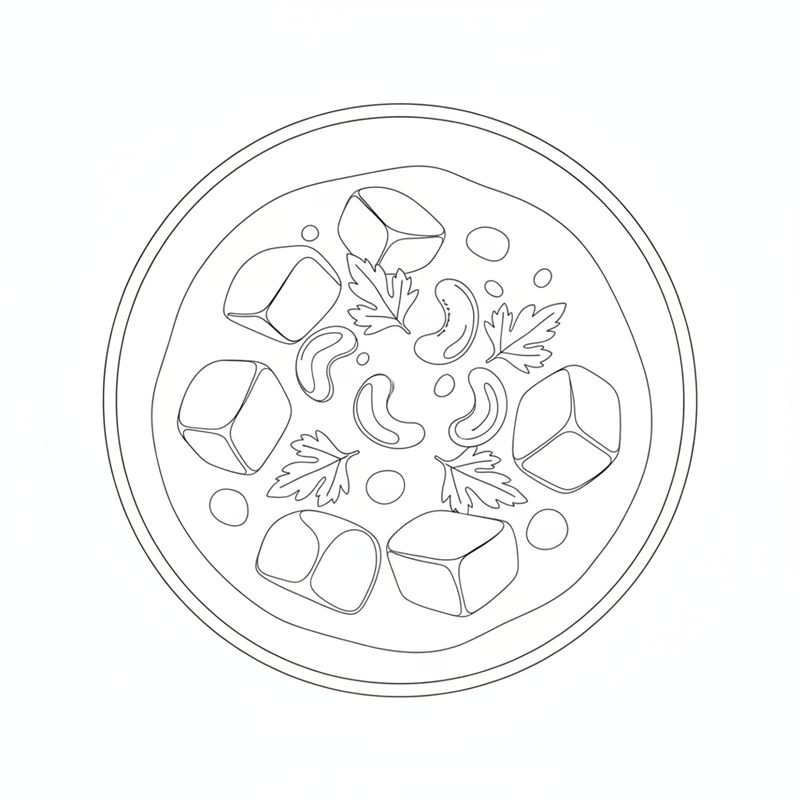 En tallerken sett ovenfra med store potetterninger i saus, cashewnøtter og persilleblader